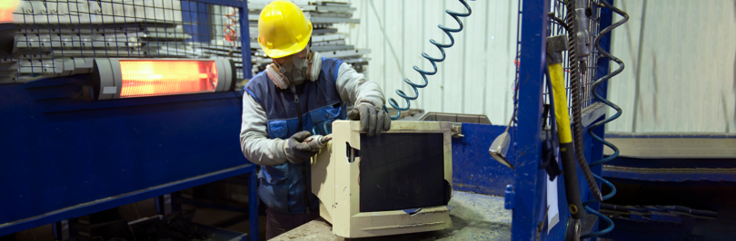 recycling worker refurbishing computer monitor