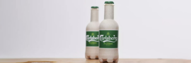 Carlsberg beer in fibre based bottle on wooden table
