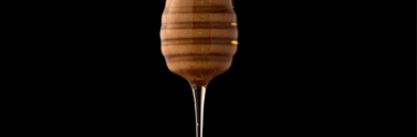 Honey dipper against black background