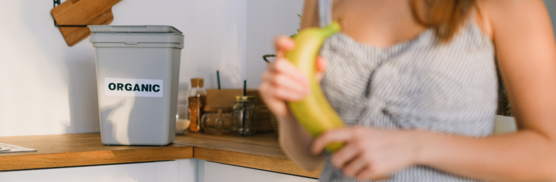 woman-holding-banana-in-front-of-organic-waste-bin