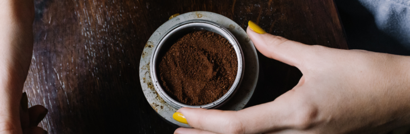 woman-holding-a-bowl-of-ground-coffee-powder