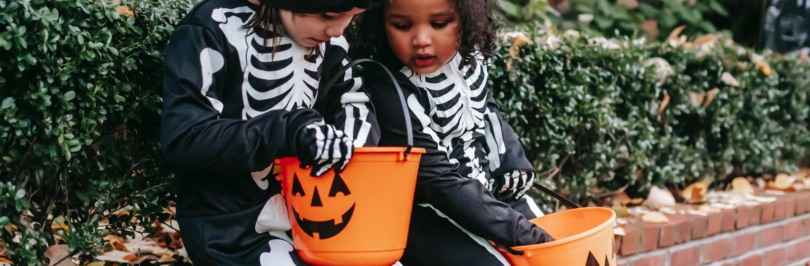 Kids-in-halloween-costumes-with-buckets-of-candies-on-street