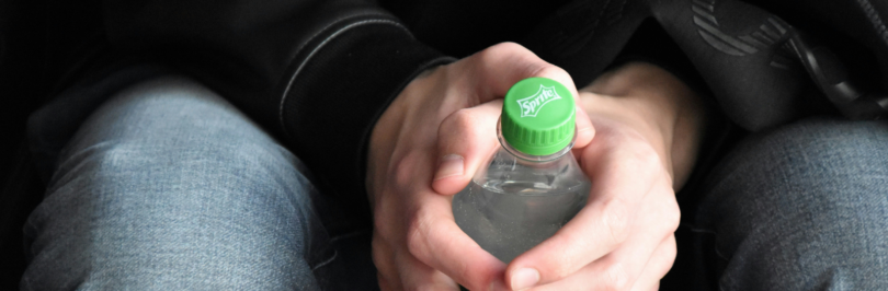 close-up-photo-of-sitting-person-holding-bottle