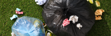 garbage-bags-with-rubbish-green-background-top-view