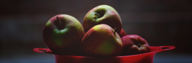 green-and-red-apples-in-red-plastic-bowl