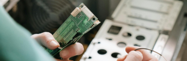 person-holding-green-and-white-electronic-board