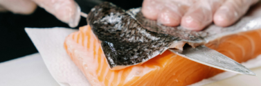 person-removing-the-skin-of-a-salmon