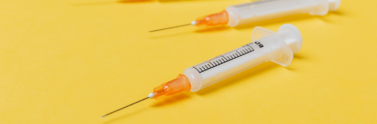 syringe-injectors-placed-on-yellow-surface