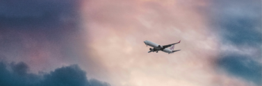 white-plane-flying-over-gray-clouds