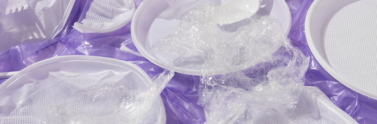 plastic bags, forks, and plates on a purple background