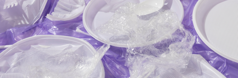 plastic bags, forks, and plates on a purple background