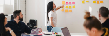 A team collaborating in a room with notes on a board