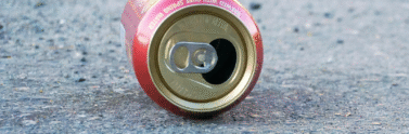 empty tin soda can lying on it's side on the ground