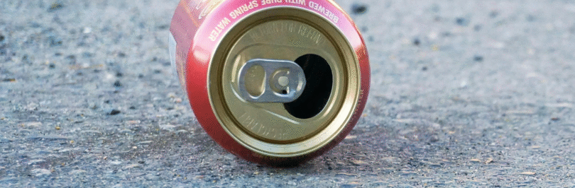 empty tin soda can lying on it's side on the ground