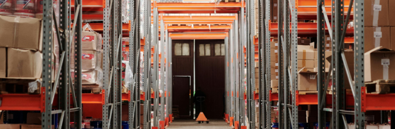 a brown door surrounded by cardboard boxes sectioned off into opposing sides of a warehouse