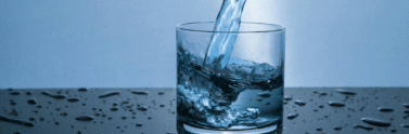 clear glass with water pouring in it