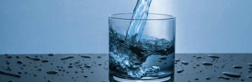 clear glass with water pouring in it