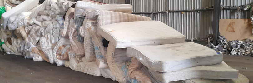 Piles of old mattresses to be recycled in warehouse