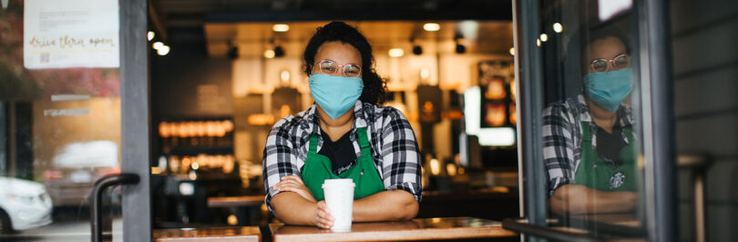 Starbucks employee holding drink