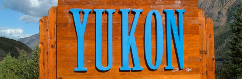 Wooden sign that reads “Welcome to Yukon: Larger than life”