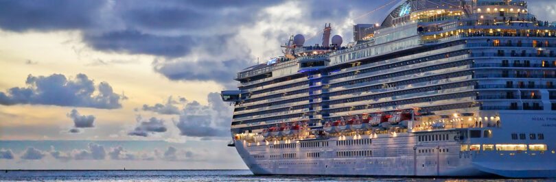 photo of a cruise ship sailing along the coast