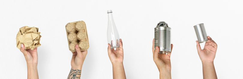 5 hands holding commonly recyclable items on white background
