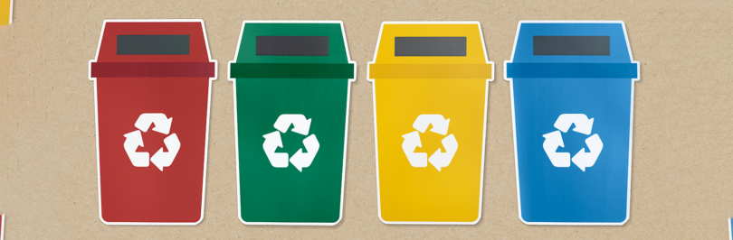 Four coloured recycling bins lined up in a row