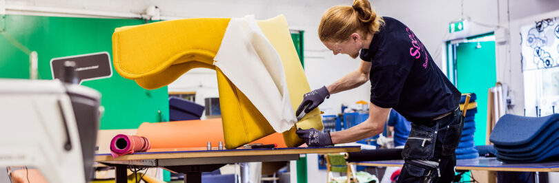 worker reupholstering armchair