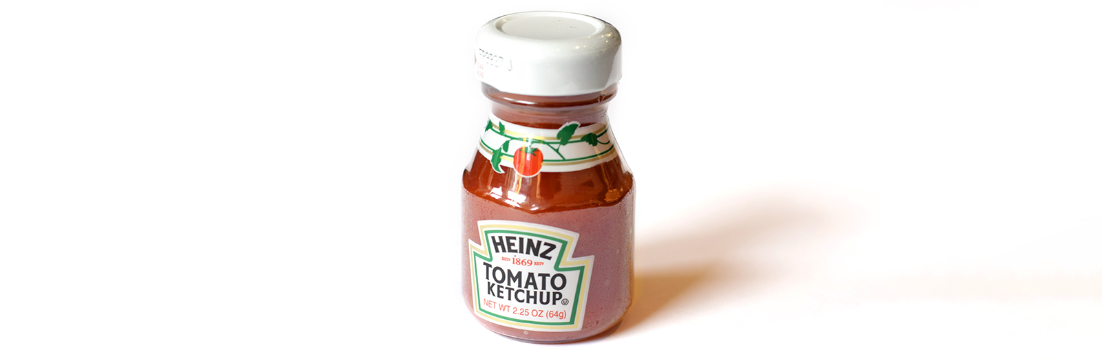 Small Heinz ketchup in glass bottle on white table