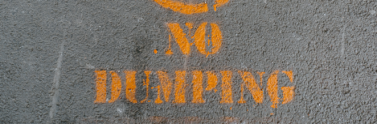 No dumping sign painted on road in yellow