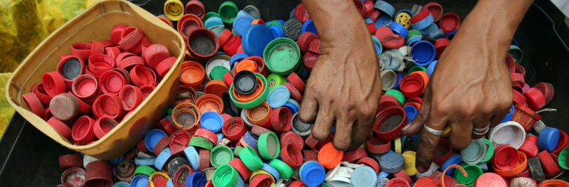 Person sorting drinking bottle lids in assorted colours