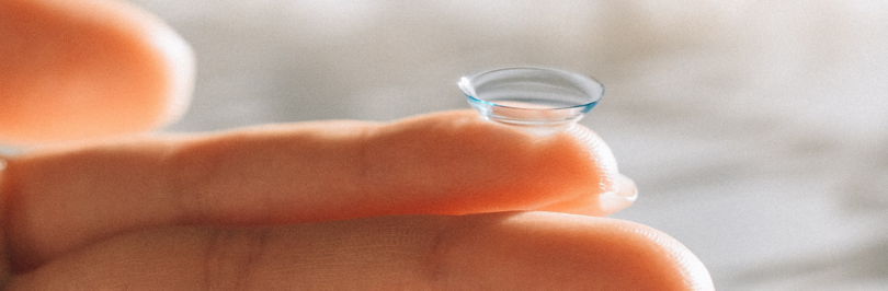 person holding contact lens on finger