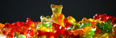 Assorted colours of gummy bears on black background