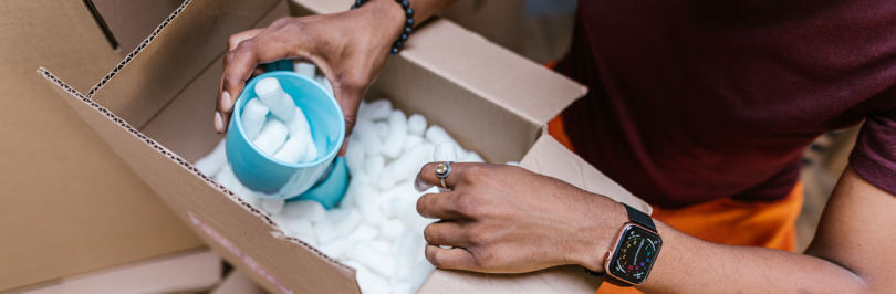 Person opening box with Styrofoam packing peanuts inside