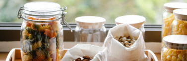 Reusable containers and bags being used to store dried pasta and nuts