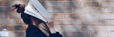 person covering their face with a book