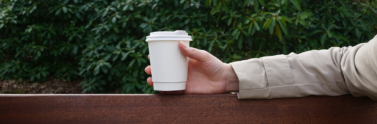 person holding paper cup