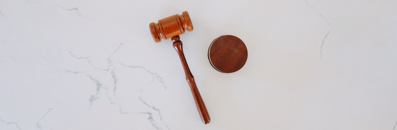 A wooden gavel on a white marble table