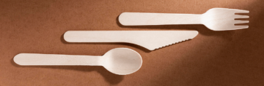 Compostable fork, knife and spoon on brown background