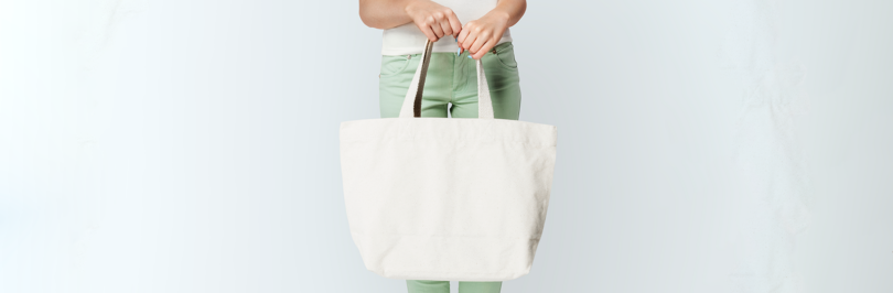 Person holding white reusable tote bag